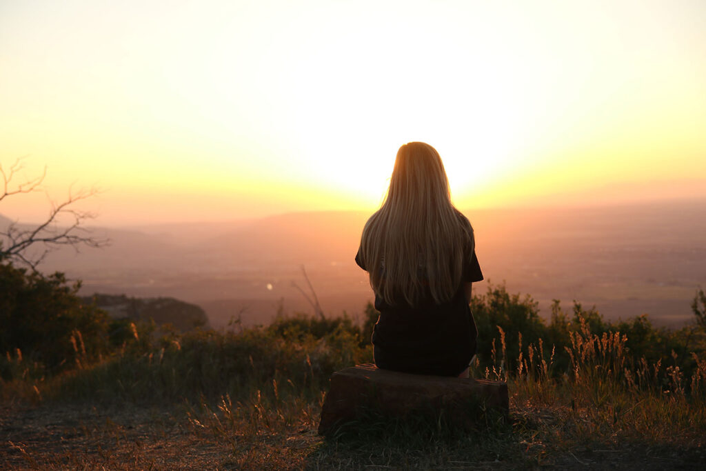 Woman overlooking a valley at sunset