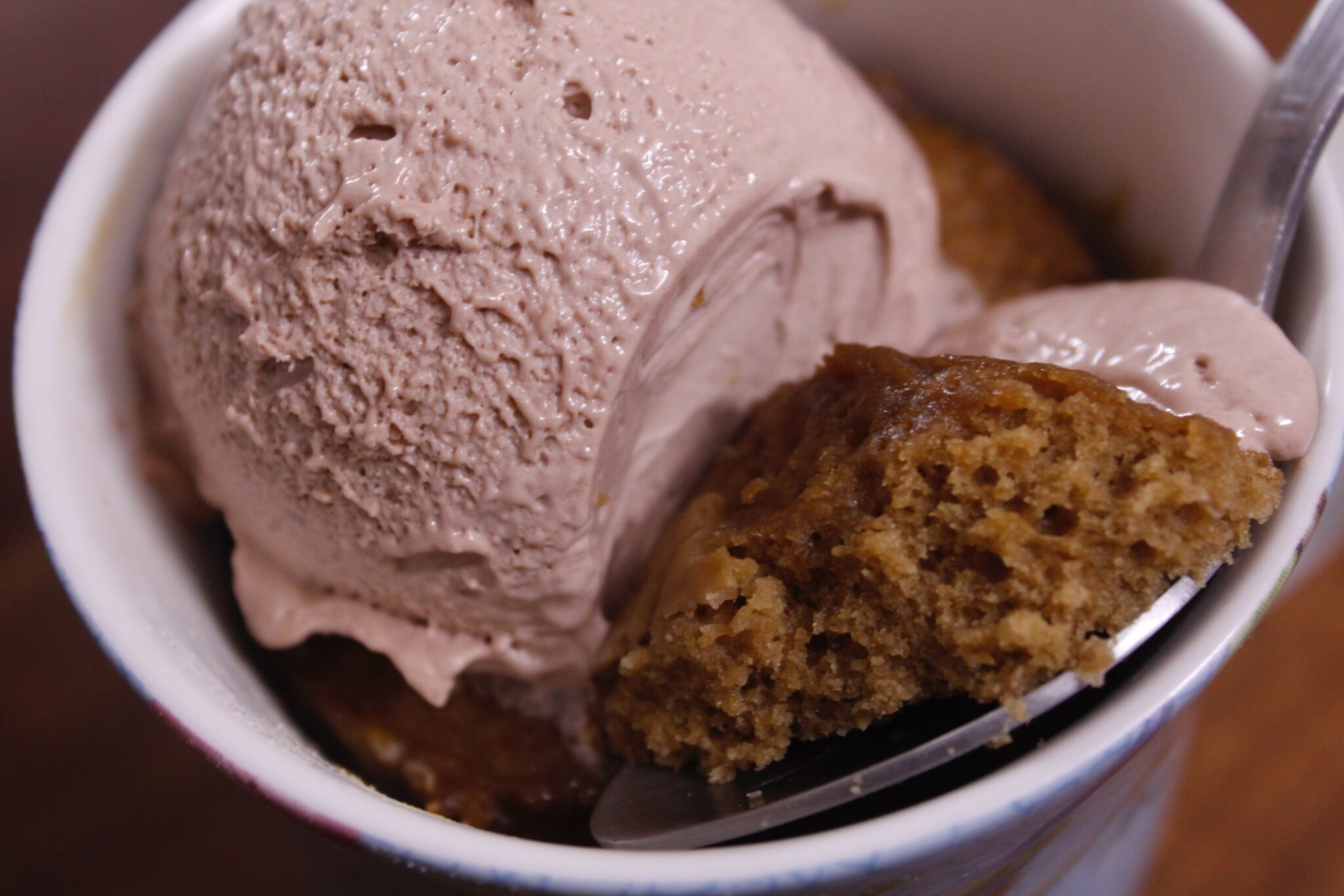 a white bowl containing a scoop of chocolate ice cream and a scoop of strawberry ice cream.