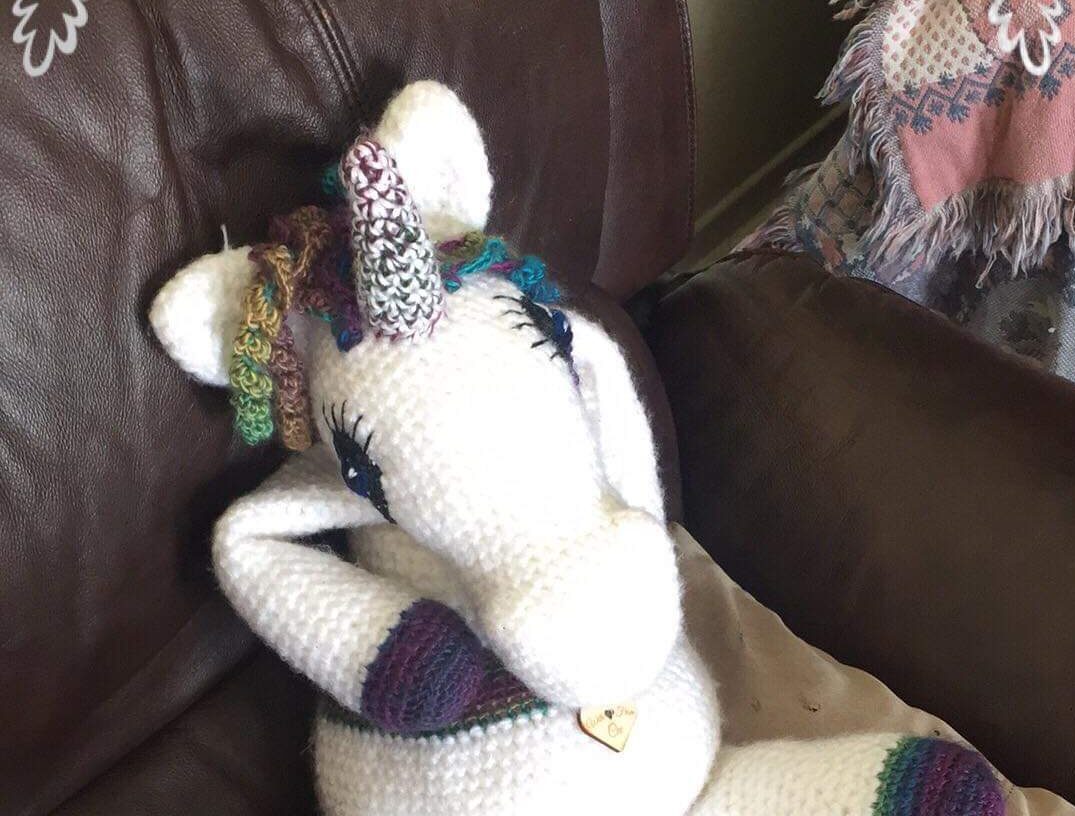 a crochet unicorn sitting on a couch