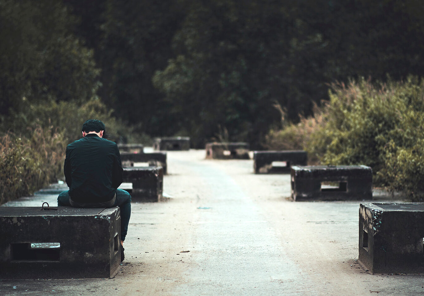 Man in black sitting on bench Man in black sitting on bench