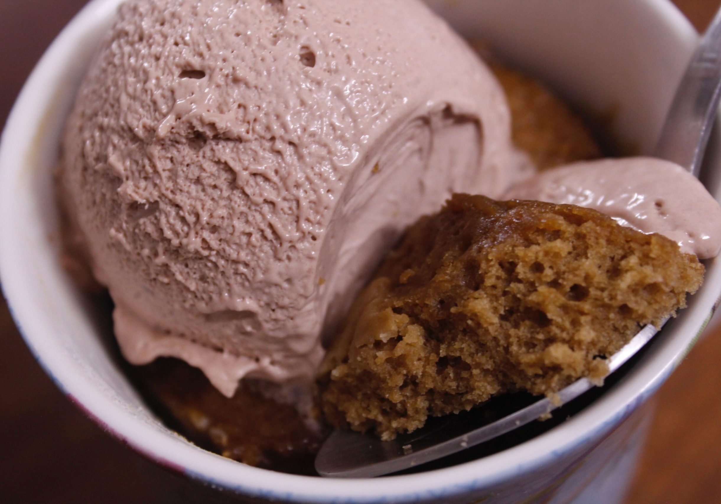 a white bowl containing a scoop of chocolate ice cream and a scoop of strawberry ice cream.