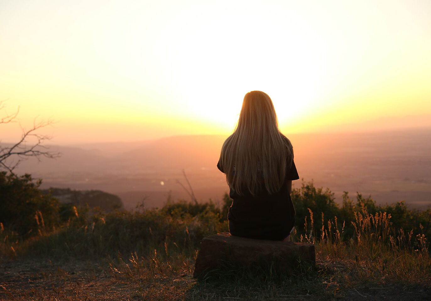 Woman overlooking a valley at sunset Woman overlooking a valley at sunset